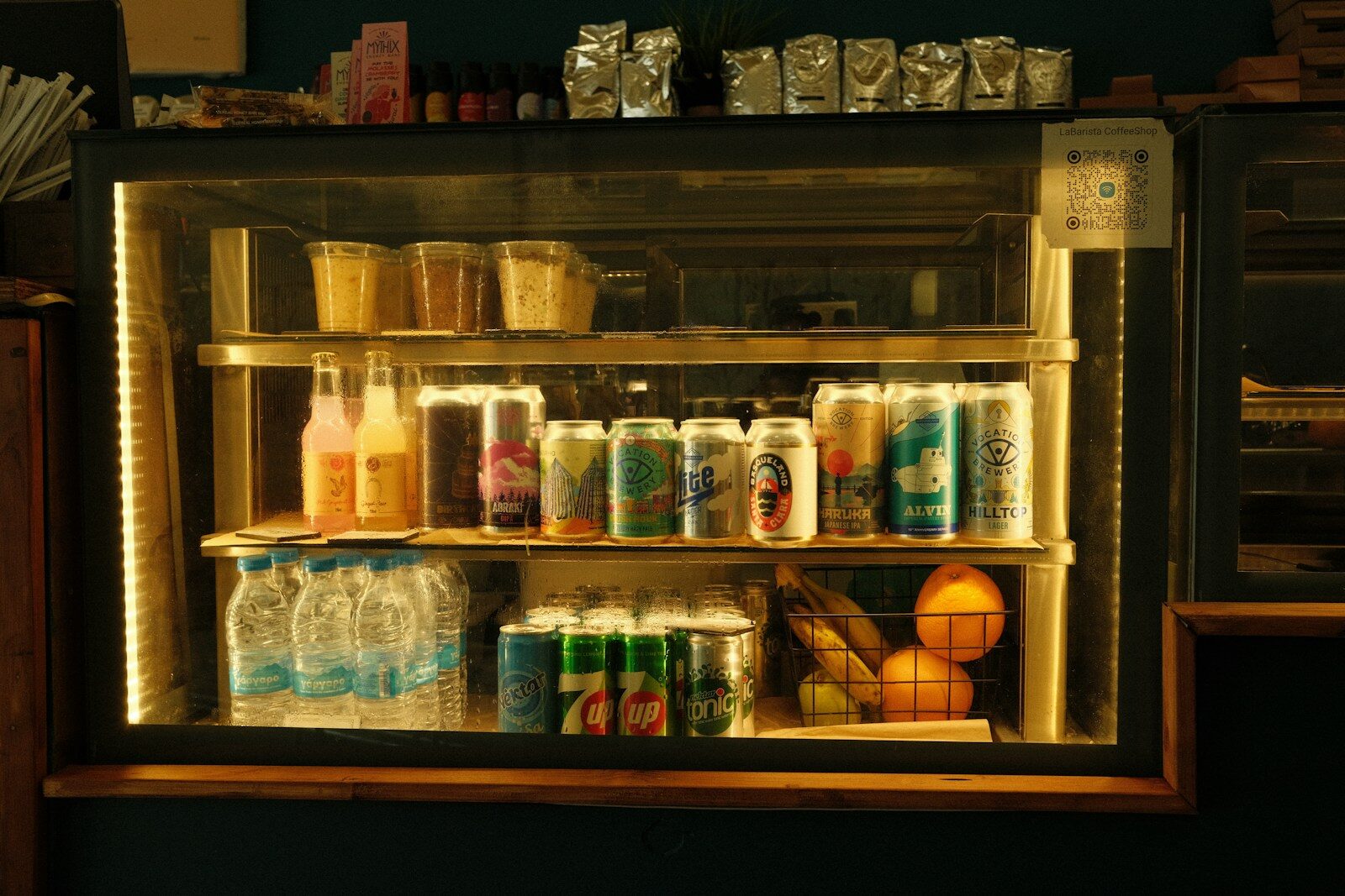 Refrigerated display case filled with drinks and fruit.