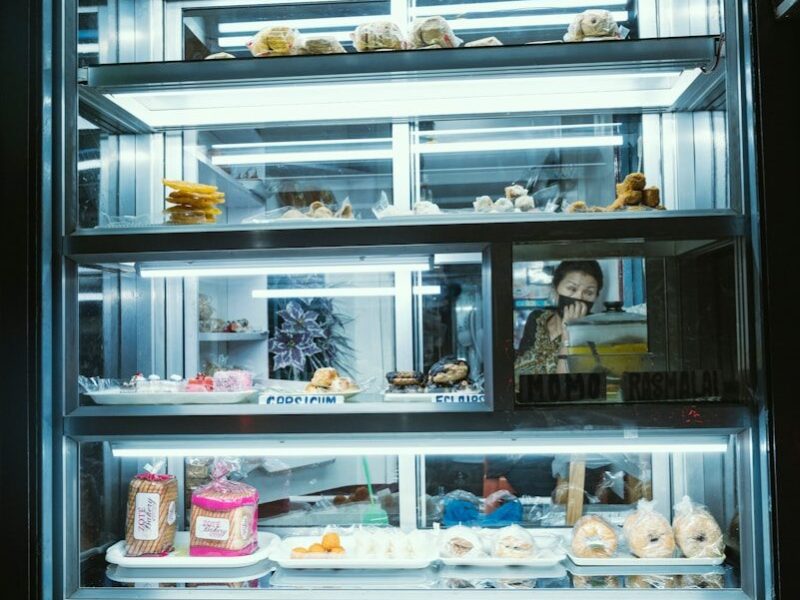 A lit display case of baked goods.
